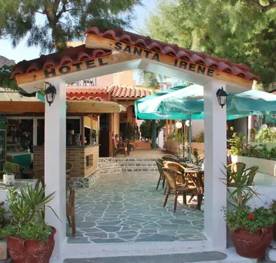 an outdoor patio with tables and umbrellas at Santa Irene in Sougia