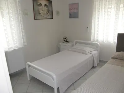 a white bedroom with a white bed and two windows at Panorama Country Residence in Tzitzifés