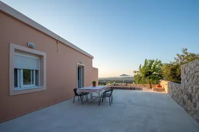 a table and chairs on the balcony of a house at Panorama Country Residence in Tzitzifés