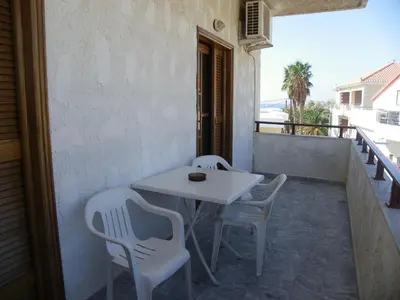 a white table and chairs on a balcony at Filoxenia Apartments 2 in Palaiochóra