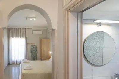a room with a bed and a mirror and a bathroom at Filoxenia Apartments 2 in Palaiochóra