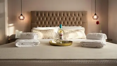 a bed with a bottle of wine and towels on it at Plaza 1866 Superior City Rooms in Chania Town