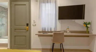a bathroom with a counter with a chair and a sink at Plaza 1866 Superior City Rooms in Chania Town