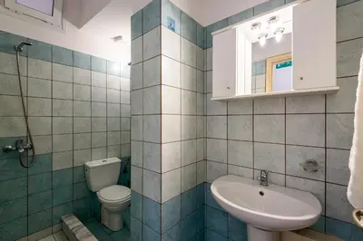 a bathroom with a toilet and a sink at Golden Beach Hill Apartments in Kato Daratso