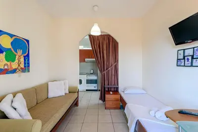 a living room with a couch and a kitchen at Golden Beach Hill Apartments in Kato Daratso