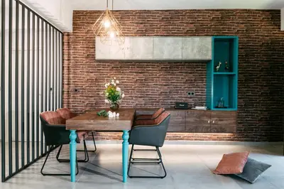 a dining room with a brick wall and a wooden table at Olvini Villa in Galatás