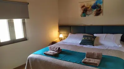 a bedroom with a bed with two towels on it at Villa Rosemari, Anatoli Apartment in Afráta