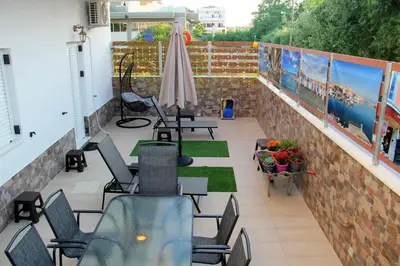 a balcony with chairs and tables and an umbrella at Chania City Home in Chania Town