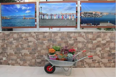 a wheelbarrow filled with plants in front of a wall at Chania City Home in Chania Town