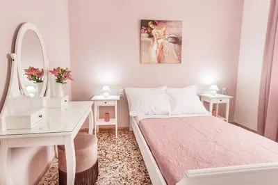 a white bedroom with a bed and a desk and a mirror at Anemelia in Chania Town