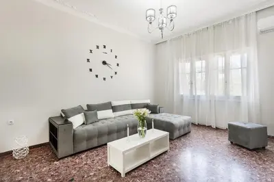 a living room with a couch and a clock on the wall at Anemelia in Chania Town