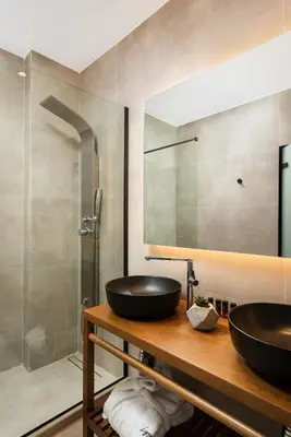 a bathroom with two sinks and a shower at Lignum Suites Chania in Chania Town