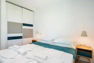 a bedroom with a bed with white sheets and pillows at Magnolia Luxury Apartments in Falasarna