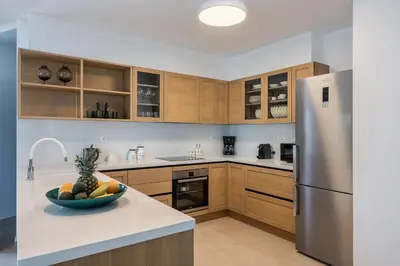 a kitchen with wooden cabinets and a bowl of fruit on a counter at Magnolia Luxury Apartments in Falasarna