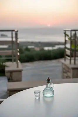 a glass jar sitting on a table with a glass cup at Magnolia Luxury Apartments in Falasarna