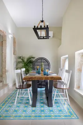 a dining room with a table and chairs on a rug at Iosifinas Boutique House in Chania Town