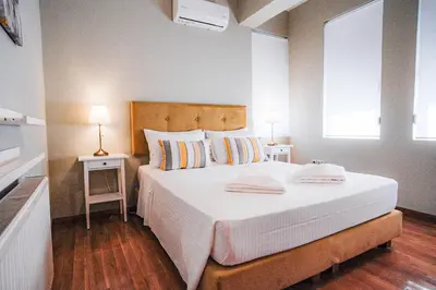 a bedroom with a large white bed with two lamps at Sweven Villa Private Pool & Absolute Privacy , Stunning Sunsets in Souda