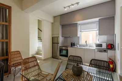 a kitchen with a table and chairs and a kitchen with a sink at Azure Beach Villas in Kissamos