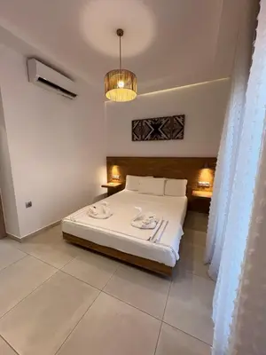 a bedroom with a bed and a chandelier at Paraskevi's Apartments in Kissamos