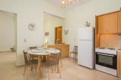 a kitchen with a table and a white refrigerator at OLIVE BREEZE in Kissamos