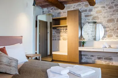 a bedroom with a mirror and a bed with towels at Kamartsos Villa 2 in Áyios Yeóryios