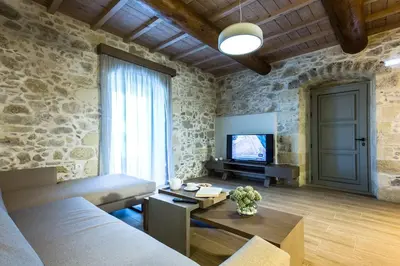 a living room with a couch and a tv at Kamartsos Villa 2 in Áyios Yeóryios