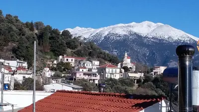 a view of a town with a snow covered mountain at Stairs Homes & Suites in Kamária