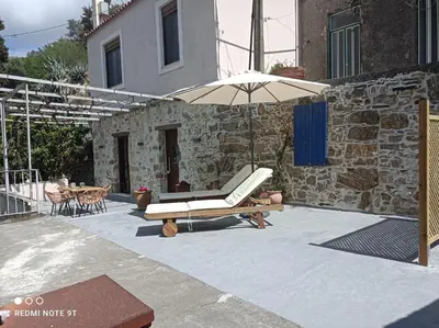 a patio with an umbrella and a table at Stairs Homes & Suites in Kamária