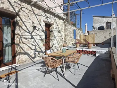 a patio with a table and chairs and a wall at Stairs Homes & Suites in Kamária