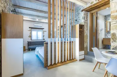 a bedroom with a bed and a table and chairs at Stairs Homes & Suites in Kamária