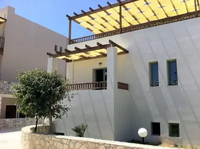 a large white house with a wooden roof at Erato Beach Hotel Adults Only by Smile Hotels in Plataniás