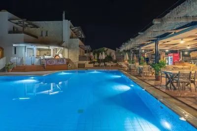 a swimming pool in a hotel at night at Erato Beach Hotel Adults Only by Smile Hotels in Plataniás