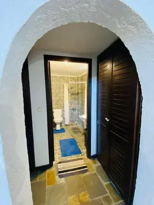 a hallway with a bathroom with a toilet and a door at The Green Home in Afráta