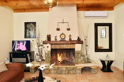 a living room with a fireplace and a couch at Raphael Evangellos Villa in Gavalochori