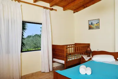 a bedroom with a bed and a large window at Raphael Evangellos Villa in Gavalochori