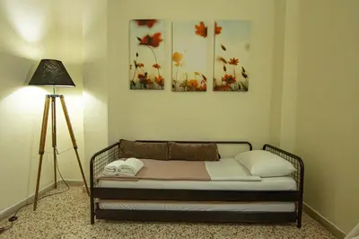 a bed in a room with three paintings on the wall at Veranda house in Chania Town