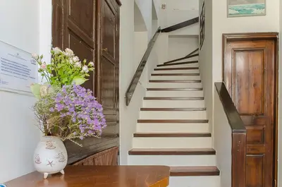 a vase of flowers on a table with a staircase at Kalypso Studios & Rooms in Palaiochóra