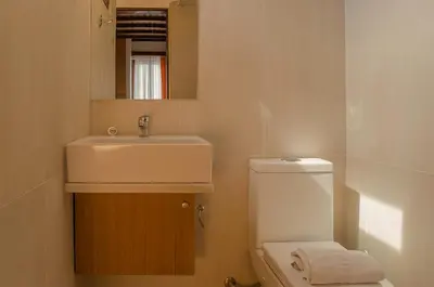 a bathroom with a sink and a toilet and a mirror at Kalypso Studios & Rooms in Palaiochóra
