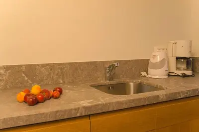 a kitchen counter with a sink and fruit on it at Kalypso Studios & Rooms in Palaiochóra