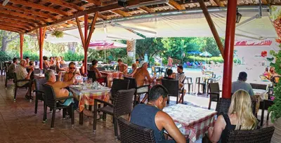 a group of people sitting at tables in a restaurant at Camping Nopigia in Kissamos