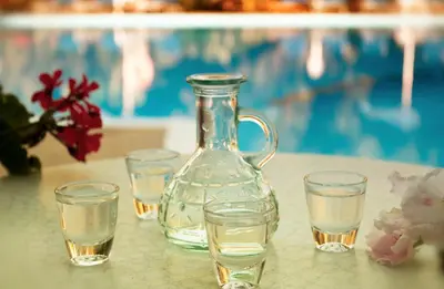 a glass vase and glasses on a table with water at Camping Nopigia in Kissamos