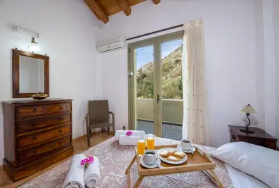 a bedroom with a bed and a table with food on it at Malathiros Traditional Villas in Maláthiros