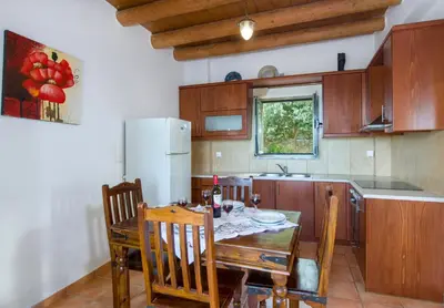a kitchen with a table and chairs and a refrigerator at Malathiros Traditional Villas in Maláthiros