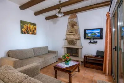 a living room with a couch and a fireplace at Malathiros Traditional Villas in Maláthiros