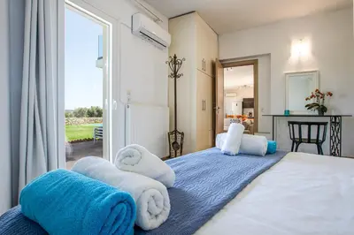 a bedroom with a large bed with towels on it at Villa PENELOPE in Galatás