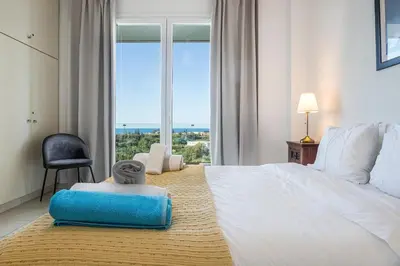 a bedroom with a large bed with a large window at Villa PENELOPE in Galatás