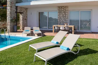 a patio with chairs and a table and a pool at Villa PENELOPE in Galatás