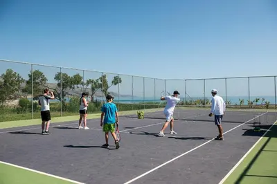 a group of people playing tennis on a tennis court at Euphoria Resort - All Inclusive in Kolymvari