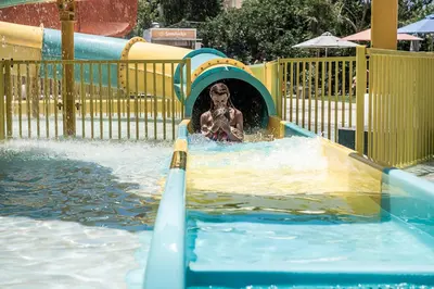 a person in a water slide at a water park at Euphoria Resort - All Inclusive in Kolymvari