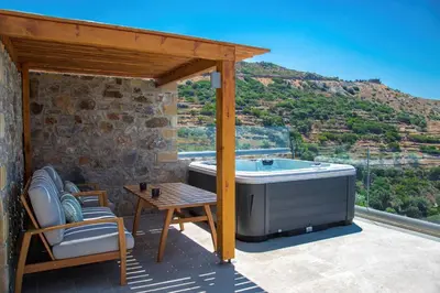 a hot tub on a patio with a table and chairs at INO I, sea goddess domus jacuzzi by Amigdalokefali Elafonissi in Kissamos